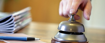 Businessman ringing a hotel reception service bell to attract attention